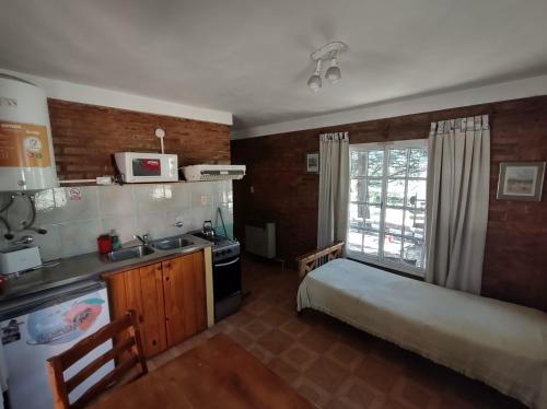 a kitchen with a bed and a sink in a room at Complejo Las Pinochas in Villa Ventana