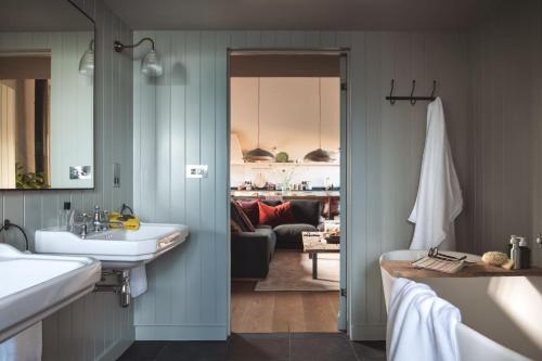 a bathroom with a sink and a living room at Exe Valley Barn in Exeter