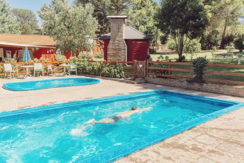 a person swimming in a swimming pool at Complejo Las Pinochas in Villa Ventana