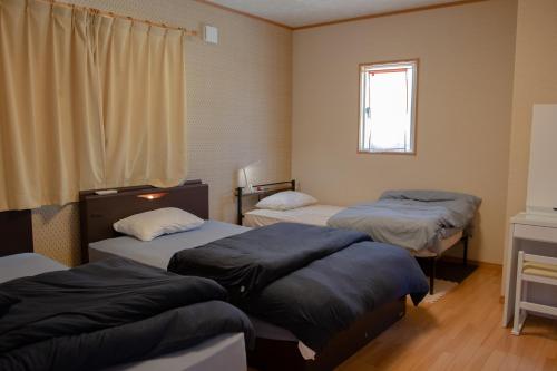 Habitación con 2 camas y ventana en GuestHouse　YOU&I, en Fujikawaguchiko