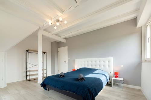 Un dormitorio con una cama azul en una habitación blanca. en Villa Centre Alsace, en Sélestat