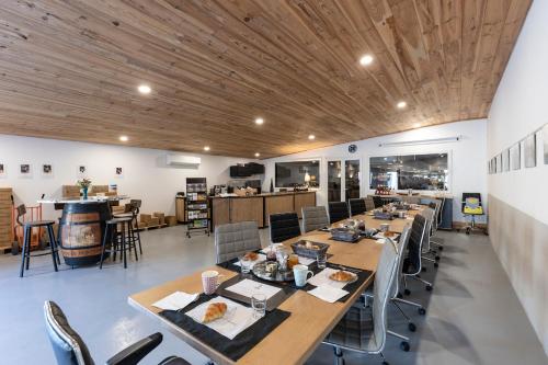 un restaurant avec des plafonds en bois, des tables et des chaises dans l'établissement Chambres d'Hôtes Château Pierre de Montignac, à Civrac-en-Médoc