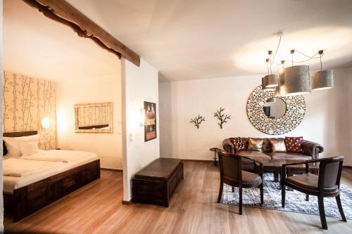 a bedroom with a bed and a table in a room at Hotel Hüttenmühle Hillscheid in Hillscheid