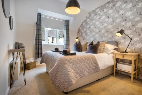 a bedroom with a large bed with a large headboard at Quarry Heights in Bowness-on-Windermere