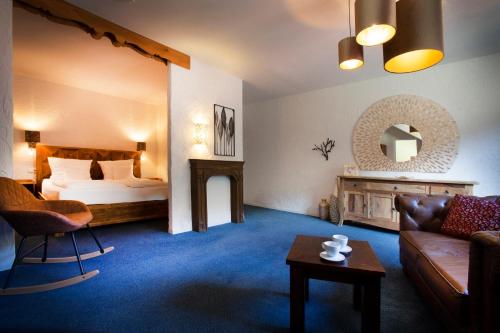 um quarto de hotel com uma cama e um sofá em Hotel Hüttenmühle Hillscheid em Hillscheid