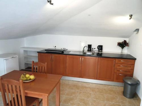 a kitchen with wooden cabinets and a table with a bowl of fruit at Quinta Coração d'Ouro in Midões