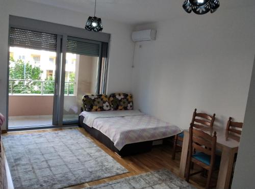 a bedroom with a bed and a chair and a window at Smakovic Apartments in Ulcinj