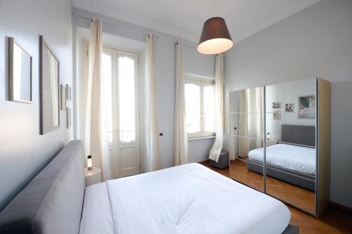 a white bedroom with a bed and a mirror at Fontana Più Stella in Rome