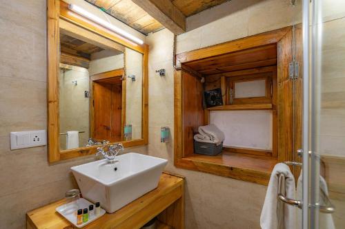 a bathroom with a sink and a mirror at StayVista at DAAFI House with Comp Breakfast in Theog