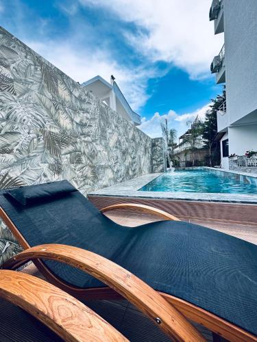 a swimming pool with a chair next to a building at Ilio Boutique Hotel in Ksamil