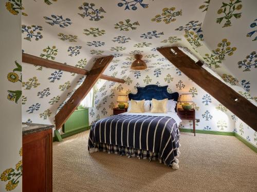 a bedroom with a bed with blue floral wallpaper at Townhouse Suites- Abbey Row in Malmesbury