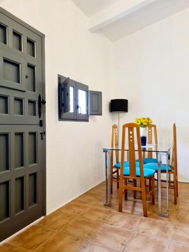 a dining room with a table and chairs and a door at Casa Tropical, serene poolside retreat in nature in Albox