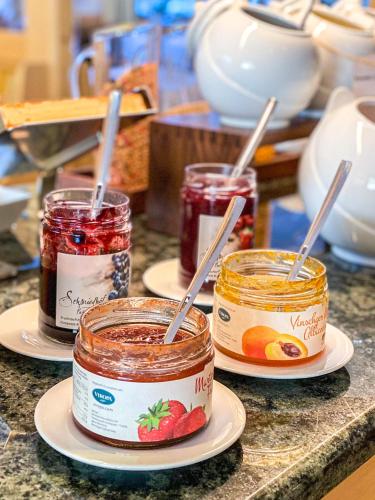 three jars of jam on plates on a counter at Garni Hotel Bel Vert in Selva di Val Gardena