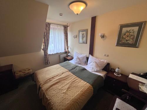 a hotel room with a bed and a window at Hotel Villa Bohema in Kazimierz Dolny