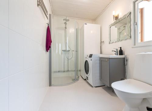 uma casa de banho com um chuveiro, um WC e um lavatório. em Lähderinne - Beachfront 2 bedroom log cabin, private beach & sauna em Puolanka