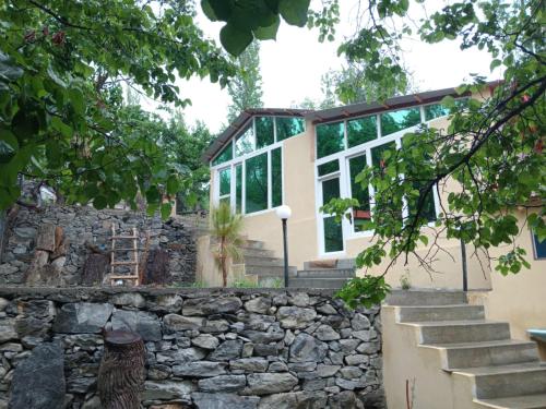 uma casa com uma parede de pedra e uma janela em Chogho-Sar Huts em Ponedas
