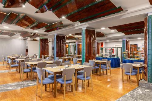 una grande sala da pranzo con tavoli e sedie di B&B Hotel Chioggia Airone a Sottomarina