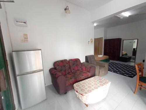 a living room with a couch and a refrigerator at Padua inn in Batu Ferringhi