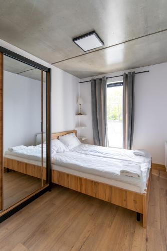 a bedroom with a large bed and a large mirror at Apartamenty Przystanek Morska in Gdynia