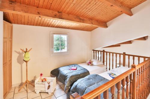 1 dormitorio con 2 camas y escalera en Camping Le Petit Rocher, en Longeville-sur-Mer