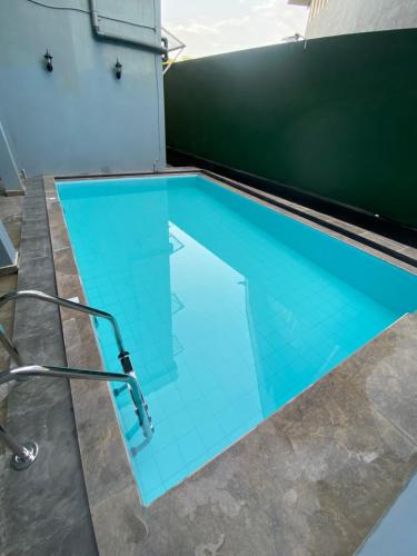 una piscina con azulejos azules en el suelo en Nirosha Guest House en Galle