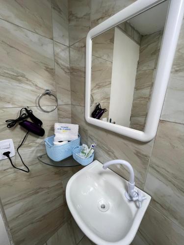 a bathroom with a sink and a mirror at Pousada Dona Felicidade Carneiros in Tamandaré