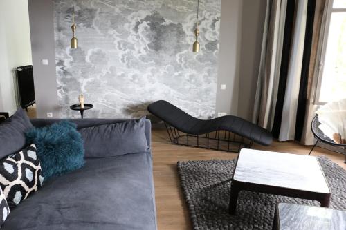 ein Wohnzimmer mit einem Sofa und einem Wandbild in der Unterkunft Maison Valmer - L'armateur, élégant penthouse classé 4 étoiles in Le Havre