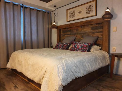 una camera da letto con un grande letto con cuscini sopra di Departamento céntrico a una cuadra del Ángel de la Independencia a Città del Messico