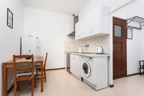 a kitchen with a washing machine and a table at City of the Kings-Camomile Apartment in Krakow