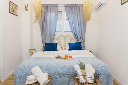 een slaapkamer met een blauw en wit bed en een raam bij Casa Thisseos in Athene