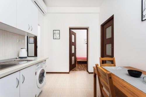 a kitchen with a sink and a washing machine at City of the Kings-Camomile Apartment in Krakow