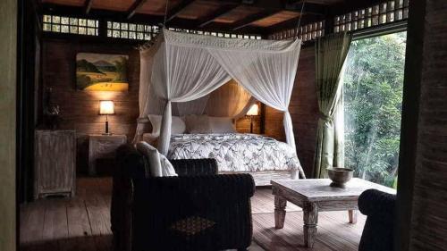 een slaapkamer met een hemelbed bij Mi Casa - The gem of Ijen in Banyuwangi