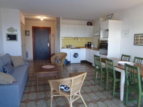 - un salon et une cuisine avec un canapé bleu et des chaises dans l'établissement Appartement T2 avec terrasse et parking à Arcachon - FR-1-374-78, à Arcachon