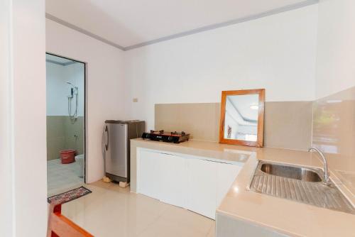 a kitchen with a sink and a refrigerator at Kawayan Hostel in General Luna