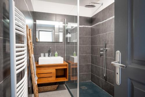 une salle de bain avec un lavabo et une douche en verre dans l'établissement Le 32 Panoramique, Plein soleil, tout confort, à Briançon