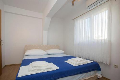 a bedroom with a bed with two towels on it at Serenity near the sea in Okrug Gornji