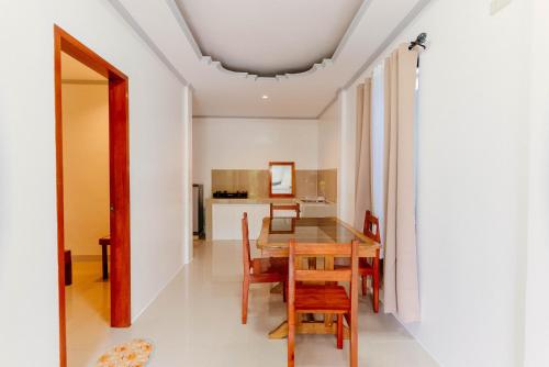 ein Esszimmer und eine Küche mit einem Tisch und Stühlen in der Unterkunft Kawayan Hostel in General Luna