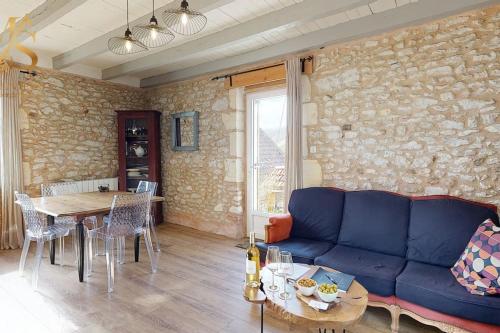 un salon avec un canapé bleu et une table dans l'établissement La Source d'Eugénie Vue Panoramique au Bugue, au Bugue