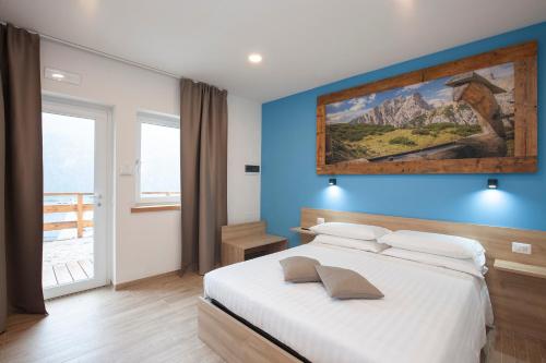 Schlafzimmer mit einem Bett mit Wandgemälde in der Unterkunft Alle Arce in Domegge di Cadore
