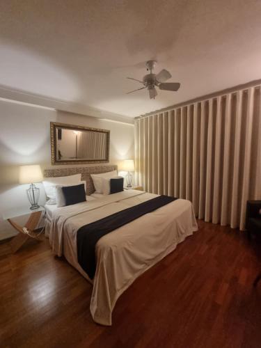 1 dormitorio con 1 cama grande y ventilador de techo en Vila De Sol, en Sesimbra