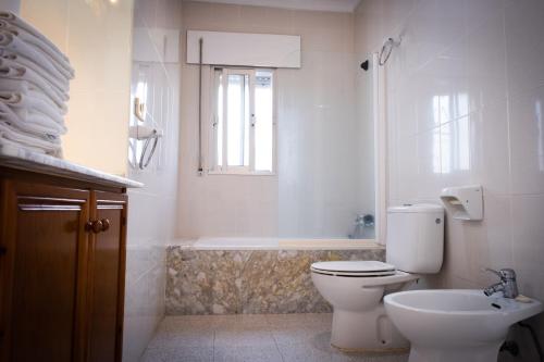 uma casa de banho com um WC, uma banheira e um lavatório. em Apartamentos Turísticos Cabo Roche em Conil de la Frontera
