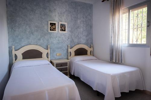 2 camas en una habitación con ventana en Apartamentos Turísticos Cabo Roche, en Conil de la Frontera