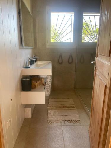 une petite salle de bain avec un lavabo et un miroir dans l'établissement L'ESQUIF, à Le Port-des-Barques