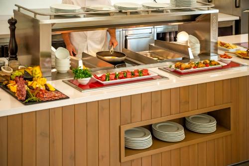 a chef preparing food in a restaurant kitchen at Cabogata Beach Hotel in Retamar