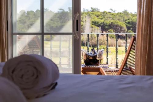 Schlafzimmer mit einem Bett und Blick auf einen Balkon in der Unterkunft Quinta Formosa - Villas in Quinta do Lago