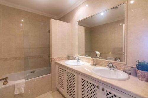 a bathroom with two sinks and a large mirror at Quinta Formosa - Villas in Quinta do Lago