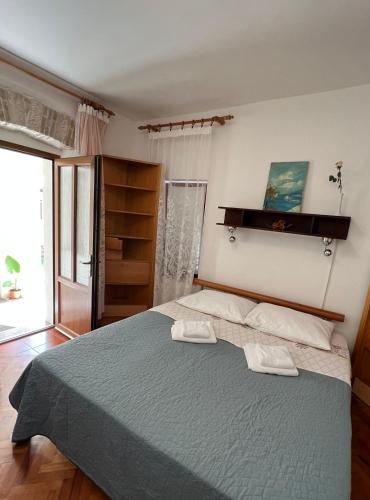 a bedroom with a large bed with two towels on it at The Green house - 20m from the beach in Novigrad Istria