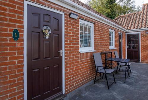 a door to a brick house with chairs and a table at Angel Inn Misson in Misson