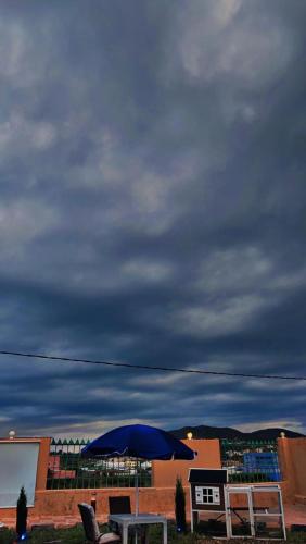 a table with an umbrella and chairs under a cloudy sky at هتان السودة Hattan Al Soudah in Suda