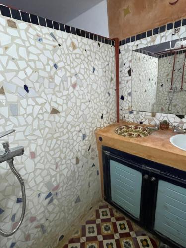 baño con lavabo y pared de azulejos en Dar el pirata, en Asilah